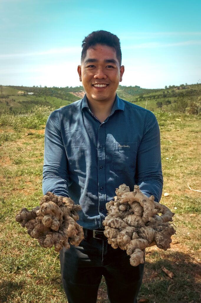 Liam Phan holding fresh ginger in a ginger field in Vietnam