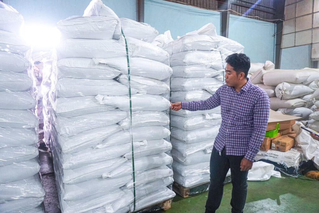 Liam Phan checking stacked and strapped bags of black pepper