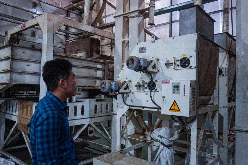 Liam Phan beside a pepper cleaning machine
