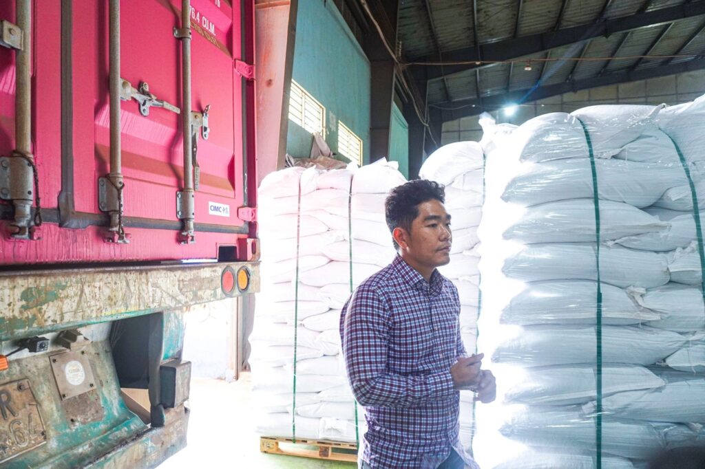 Bags of black pepper stacked beside a container
