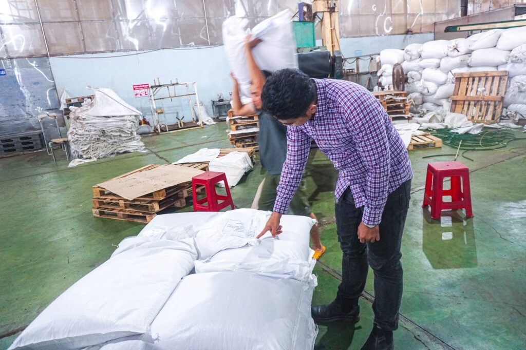 Liam Phan checking packed bags of pepper